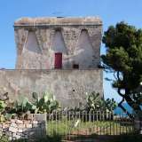 Circondata da numerosi cactus, un muretto a secco e da un cancelletto in ferro, la torre presenta evidenti strati di intonaco sulla pietra tufacea originaria e risulta per questo pi� bianca rispetto alle altre. Sempre a pianta quadrata, mostra un muretto superiore di protezione leggermente arrotondato e delle finestrelle chiuse con tegole in legno color porpora